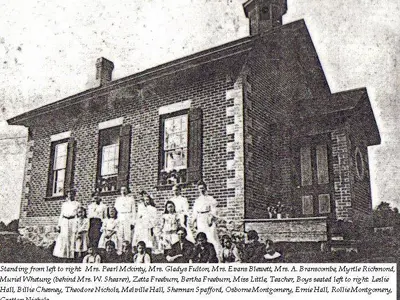 picture of buckhorn library as schoolhouse with children in front of it